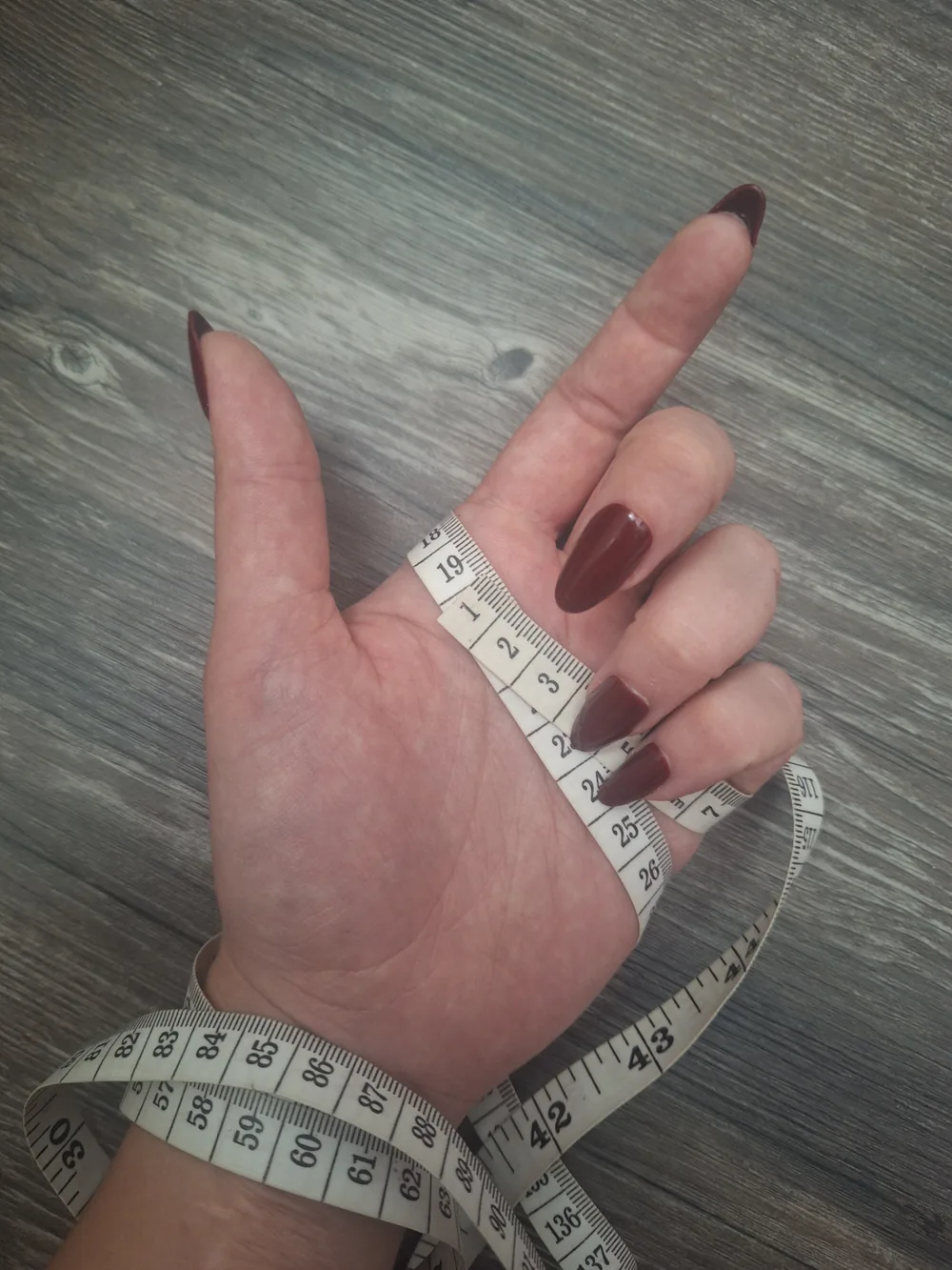 Hand mit Maßband um die Handfläche gelegt, Umfangmessung, Ablesepunkt bei 19 Zentimetern